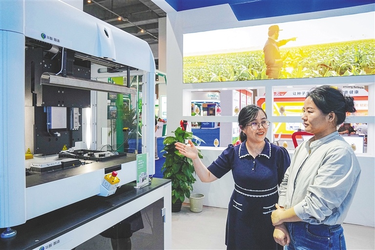 3月18日，在三亚举办的2024中国种子大会室内展览现场，与会嘉宾前来观看展示的用于生物育种的自动化设备。海南日报记者王程龙 摄