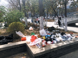 街心花园堆放垃圾成卫生死角垃圾清理不能靠风吹